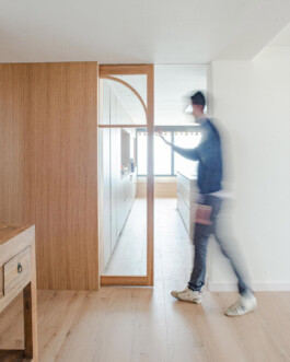 Hombre abriendo la puerta corredera de la cocina de Bahía 19. Proyecto de Juan Parra Arquitectura