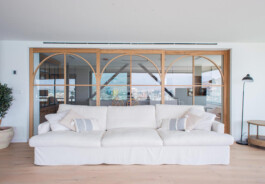 Cocina conectada al salón a través de la cristalera y madera de Bahía 19. Proyecto de Juan Parra Arquitectura 